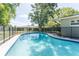 Backyard view featuring an in-ground pool, large trees, green grass, and a privacy fence at 503 Gumwood Ct, Altamonte Springs, FL 32714