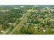 Scenic aerial view showcases a neighborhood surrounded by lush greenery and mature trees with railroad tracks running through at 5851 Se Drew Rd, Belleview, FL 34420