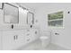 Bathroom featuring double sink vanity, black hardware, a marble floor, and plenty of natural light at 5851 Se Drew Rd, Belleview, FL 34420