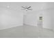 Spacious bedroom featuring white walls, tile floors, ceiling fan and adjoining bathroom at 5851 Se Drew Rd, Belleview, FL 34420