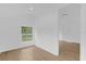 Light and airy bedroom with wood floors, neutral walls, and a view of lush greenery at 5851 Se Drew Rd, Belleview, FL 34420