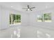 Bright bedroom featuring sliding glass doors to the deck, large window, and a neutral color palette at 5851 Se Drew Rd, Belleview, FL 34420
