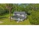 Charming two-story home with a welcoming front porch surrounded by a lush lawn and mature palm trees at 5851 Se Drew Rd, Belleview, FL 34420