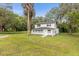 Charming two-story home features a welcoming front porch and is surrounded by lush greenery and majestic palm trees at 5851 Se Drew Rd, Belleview, FL 34420