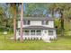 Charming two-story home with a white exterior, well-manicured lawn, and a welcoming front entrance at 5851 Se Drew Rd, Belleview, FL 34420