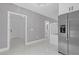 Bright hallway with neutral walls, stainless steel refrigerator, and doorways leading to other rooms in the house at 5851 Se Drew Rd, Belleview, FL 34420