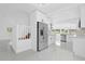 Open-concept interior with white cabinets, stainless steel appliances, and a staircase leading to the upper level at 5851 Se Drew Rd, Belleview, FL 34420
