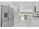 Modern white kitchen featuring stainless steel appliances, marble countertops, and a large window with outdoor views at 5851 Se Drew Rd, Belleview, FL 34420