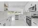 Bright kitchen featuring white cabinets, stainless steel appliances, and marble countertops at 5851 Se Drew Rd, Belleview, FL 34420