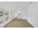 Bright living room featuring wood floors, neutral walls, and natural light from large windows at 5851 Se Drew Rd, Belleview, FL 34420