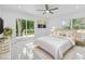 A bright main bedroom featuring stylish decor, a modern ceiling fan, and a sliding glass door to the deck at 5851 Se Drew Rd, Belleview, FL 34420