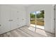 A bedroom shows wood-look floors, a closet with double doors, and a glass door to the yard at 610 E Euclid Ave, Deland, FL 32724
