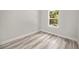 Empty bedroom showcases wood-look floors and a window with a view of greenery at 610 E Euclid Ave, Deland, FL 32724