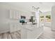 Modern kitchen with white cabinets, quartz countertops, an island, stainless steel appliances, and stylish pendant lighting at 610 E Euclid Ave, Deland, FL 32724