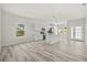 Open-concept living room and kitchen with hardwood floors, white walls, and plenty of natural light at 610 E Euclid Ave, Deland, FL 32724