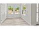 Bright living room featuring hardwood floors, white walls, a double door closet and many windows at 610 E Euclid Ave, Deland, FL 32724