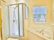 Bathroom showcasing a glass-enclosed shower and separate tub with natural light from a window at 671 Carey Way, Orlando, FL 32825