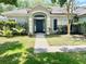 Inviting single-Gathering home with neutral exterior paint, arched entry and well-manicured front lawn, exemplifying suburban charm at 671 Carey Way, Orlando, FL 32825
