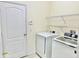 Functional laundry room with modern appliances, including a white washer and dryer, and storage shelves at 671 Carey Way, Orlando, FL 32825