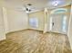 Spacious living room featuring wood-look floors, ceiling fan, and a front door with sidelights for ample natural light at 671 Carey Way, Orlando, FL 32825