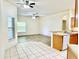 Open layout with wood-look floors connecting the living area to the kitchen with tile flooring at 671 Carey Way, Orlando, FL 32825