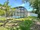 Screened-in pool with clear water, surrounded by a well-kept lawn and trees at 671 Carey Way, Orlando, FL 32825