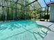 A sparkling in-ground pool and screened-in enclosure with lights create an inviting backyard oasis at 671 Carey Way, Orlando, FL 32825