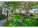 Expansive backyard with lush green grass, mature trees, and peaceful seating area at 714 Regina Cir, Oakland, FL 34787