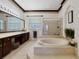 Elegant bathroom featuring a soaking tub, glass shower, and double vanity with lots of counter space at 714 Regina Cir, Oakland, FL 34787