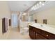 Bright bathroom featuring a double vanity, a separate shower, and a door to the backyard at 714 Regina Cir, Oakland, FL 34787