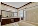 Elegant bathroom featuring a soaking tub, glass shower, and double vanity with dark wood cabinets at 714 Regina Cir, Oakland, FL 34787