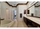 Elegant bathroom featuring a soaking tub, tan tile, double vanity, and separate shower at 714 Regina Cir, Oakland, FL 34787