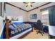 Comfortable bedroom with blue walls, and ceiling fan with a TV and desk at 714 Regina Cir, Oakland, FL 34787
