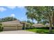Well-maintained home featuring a three-car garage, lush landscaping, and inviting curb appeal at 714 Regina Cir, Oakland, FL 34787