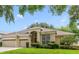 Charming home featuring a three-car garage, manicured lawn, and beautiful landscaping at 714 Regina Cir, Oakland, FL 34787
