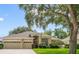 Beautiful home features a three-car garage, manicured lawn, and mature trees for added curb appeal at 714 Regina Cir, Oakland, FL 34787