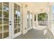 Balcony with double doors and a ceiling fan offering a view of trees and a neighboring balcony at 7505 Mourning Dove Cir # 201, Reunion, FL 34747