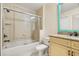 Bathroom featuring a tiled shower with glass door, toilet, and granite vanity with decorative mirror at 7505 Mourning Dove Cir # 201, Reunion, FL 34747