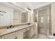 Bathroom featuring a large mirror over a double vanity and a tiled shower with glass doors at 7505 Mourning Dove Cir # 201, Reunion, FL 34747