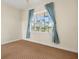 Neutral bedroom with patterned carpet and large window framed by striking blue curtains at 7505 Mourning Dove Cir # 201, Reunion, FL 34747