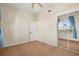 Bedroom with patterned carpet, a mirrored closet door, and a bright window with blue curtains at 7505 Mourning Dove Cir # 201, Reunion, FL 34747