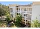 Multi-story condo building features balconies and mature trees in a landscaped setting at 7505 Mourning Dove Cir # 201, Reunion, FL 34747
