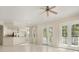 Spacious living area with tiled flooring, a ceiling fan, and seamless access to the modern kitchen and exterior balcony at 7505 Mourning Dove Cir # 201, Reunion, FL 34747