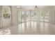 Bright and airy living room featuring tile floors, multiple French doors, and abundant natural light at 7505 Mourning Dove Cir # 201, Reunion, FL 34747
