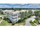 Aerial view of a yellow/white building complex with manicured landscaping and palm trees at 7509 Mourning Dove Cir # 201, Reunion, FL 34747