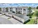 Aerial view featuring a yellow/white building with garages, palms, and manicured shrubs at 7509 Mourning Dove Cir # 201, Reunion, FL 34747