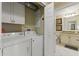 Laundry room with white washer/dryer leading to adjacent bathroom with vanity at 7509 Mourning Dove Cir # 201, Reunion, FL 34747