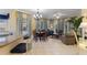 Open-plan living room featuring tile floors, elegant furnishings, and natural light streaming through large windows at 7509 Mourning Dove Cir # 201, Reunion, FL 34747