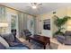 Spacious living room with a ceiling fan, access to the balcony, a tv, and cozy seating at 7509 Mourning Dove Cir # 201, Reunion, FL 34747