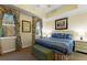 Bright main bedroom with a tray ceiling, soft carpet, and a large bed with decorative pillows at 7509 Mourning Dove Cir # 201, Reunion, FL 34747